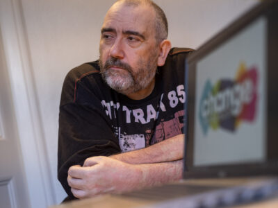 man sitting at the desk with Change Mental Health logo