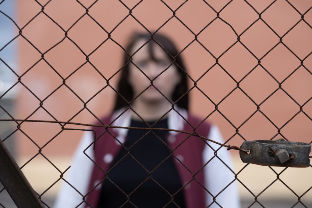 Schizophrenia - women standing behind fencing