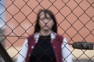 Schizophrenia - women standing behind fencing