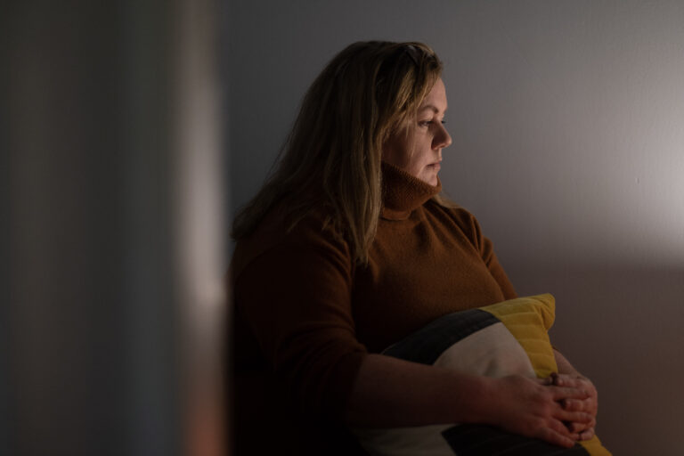 Suicide Bereavement Support - sad women seating in half lit room