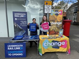Two publicity stands in Leven featuring Levenmouth Rail Link and Change Mental Health, both people holding a sign