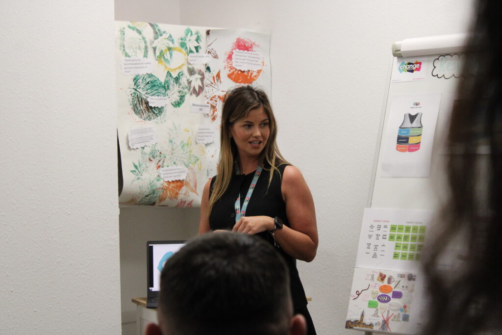 A women during workshop standing next to training materials on a board - supporting neurodiverse people
