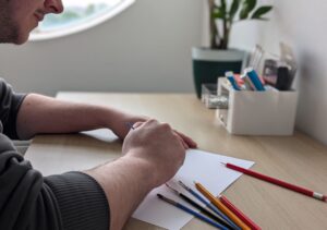 man seating with art supplies - volunteering