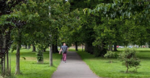 men walking through a green park in short sleeve - men's mental health