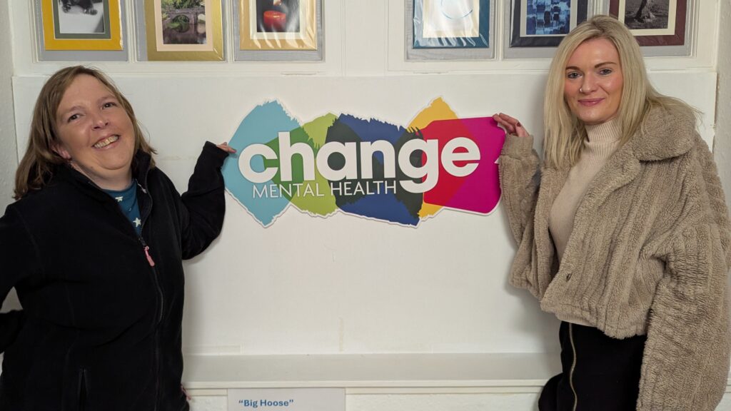 PXL_20250319_143823422MP - Change Mental Health two women - Lorna and Sarah-Jayne - with change mental health sign. Lorna has been previously supported by carer support