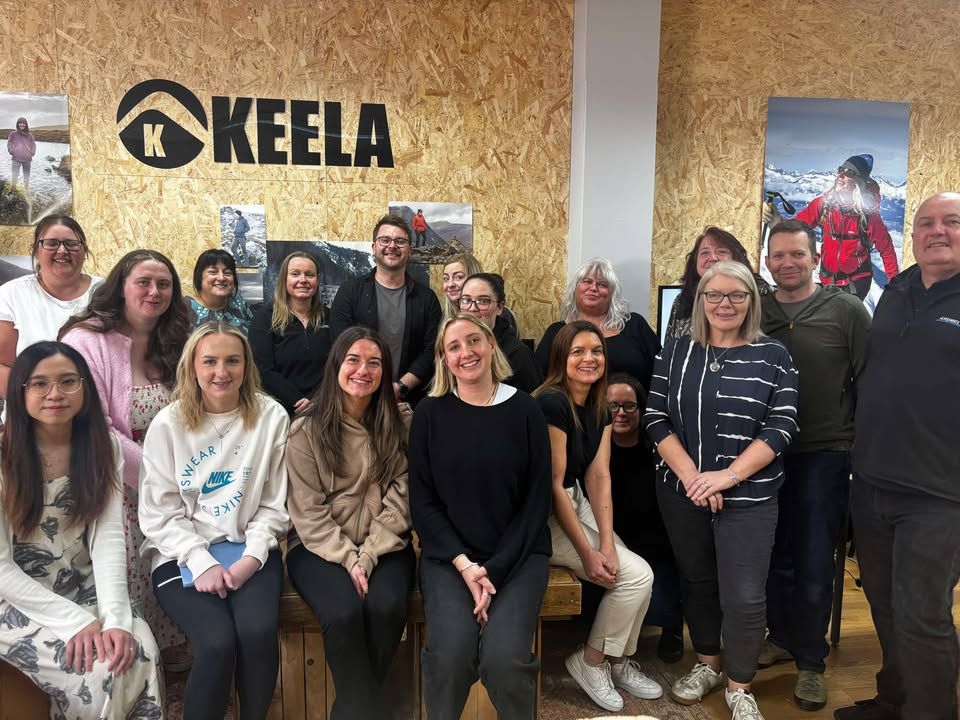Change Mental Health training team with Keela Outdoors team during the delivery of the Building Resilience in the Workplace session - group of people standing in front of Keela Outdoors logo