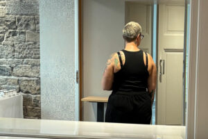 understanding stigma - womens reflection in the mirror looking towards the doors