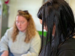 Donna’s story: When traditional services didn’t work, person-centred support in community did - black haired women in the first plan and blurred imnage of women in the background