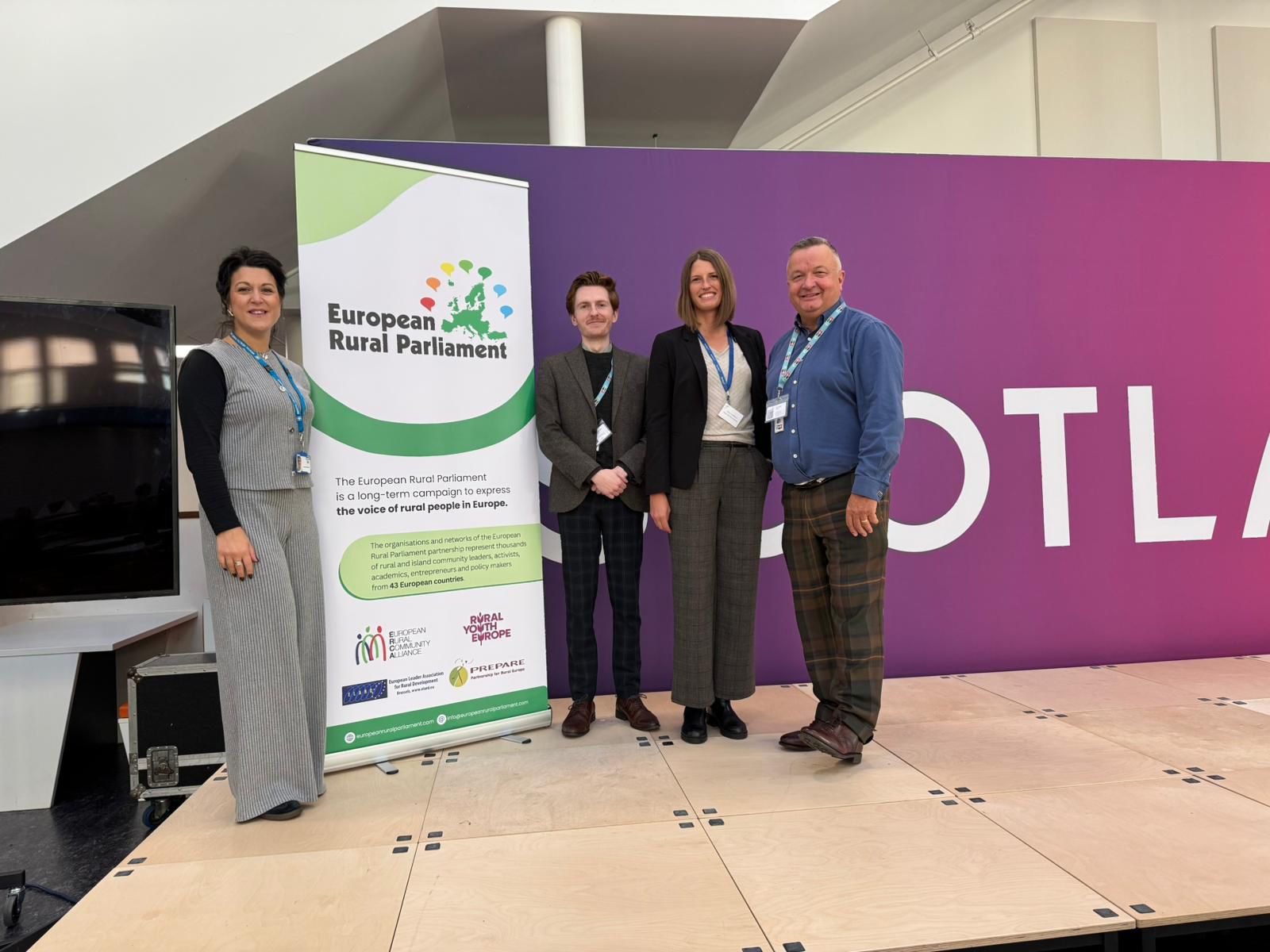 Four people next to a pop-up banner that says European Rural Parliament.