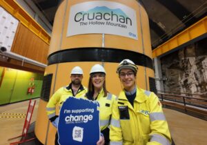 Three people in work wear standing in the Cruachan Power Station. Change Mental Health partners with Drax to offer dynamic mental health training across rural Scotland at the Cruachan Power Station.