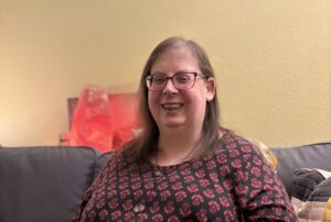 Marcy - a woemen in glasses smiling - Marcy’s story: Making space to talk about voices
