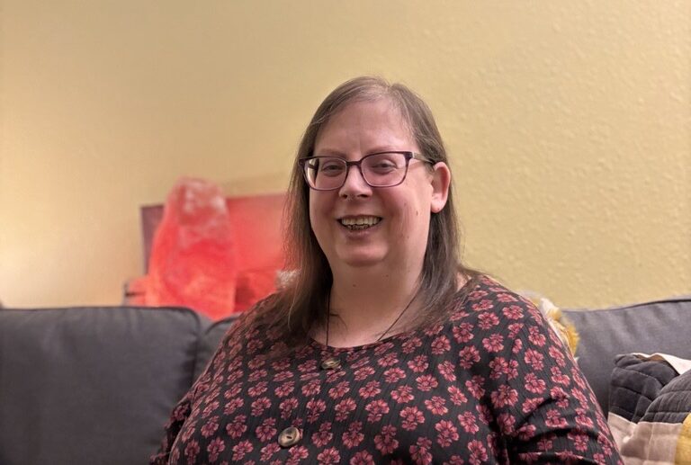 Marcy - a woemen in glasses smiling - Marcy’s story: Making space to talk about voices