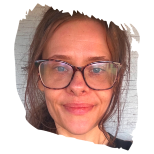 Close-up portrait of a woman with brown hair and glasses, smiling slightly, cropped at the forehead and chin.