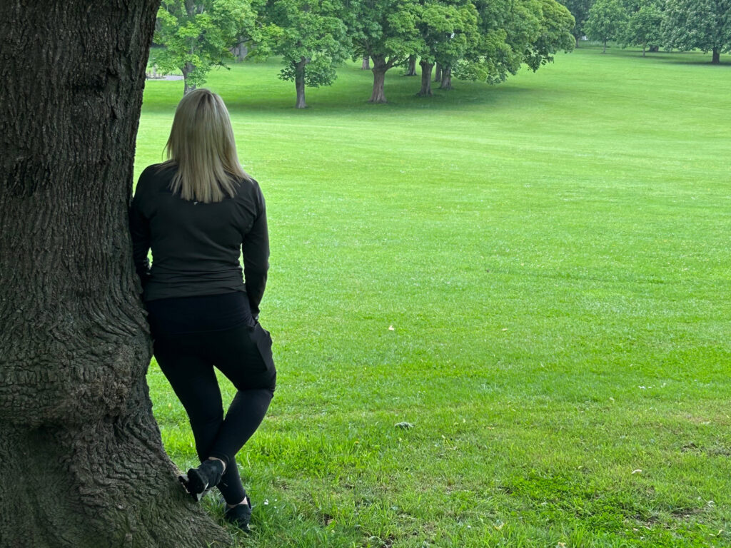 Women standing in the park under the tree - Lorraine talking about what does it feel like to hear voices