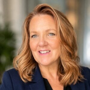 Georgina McBroom - Professional headshot of a smiling woman with light brown hair wearing a navy blazer.